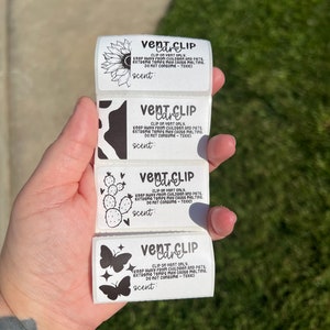 May include: Four white labels with black text and images. Each label says "Vent Clip Care" and includes instructions for using the vent clip. The images are a sunflower, a cow, a cactus, and a butterfly.
