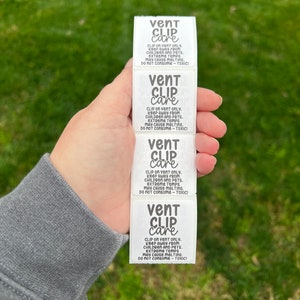 May include: Four white labels with black text that reads "vent clip care" and instructions to keep away from children and pets, as well as to avoid consuming the product because it is toxic.