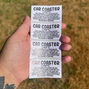 May include: A stack of white rectangular stickers with the text "CAR COASTER care" in a handwritten style font. The stickers provide care instructions, including spot cleaning with dish soap and warm water.