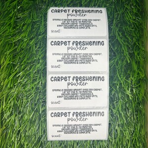May include: Four white labels with black text that reads "Carpet Freshening Powder". The labels have instructions for using the powder, including letting it sit for 15-30 minutes, vacuuming thoroughly, and keeping children and pets away until vacuuming is complete. The labels also have the word "scent" on them.