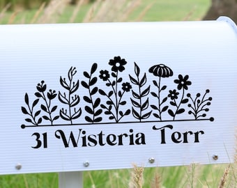 May include: White mailbox with a black floral design and the address "31 Wisteria Terr" printed below. A red flag is attached to the mailbox.
