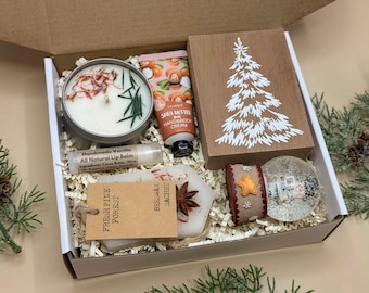 Könnte beinhalten: Geschenkbox mit einer Kerze, Handcreme, Lippenbalsam, einem Holzblock mit einem Weihnachtsbaumdesign, einer Schneekugel und einem Bienenwachs-Sachet. Die Box enthält den Text "Fresh Pine Forest".