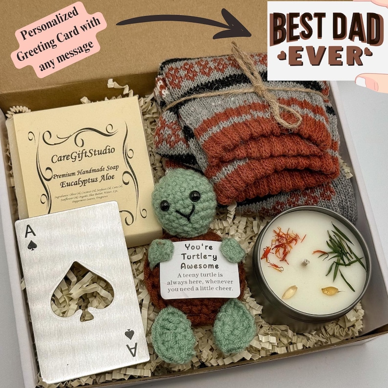 May include: A gift box containing a handmade soap, a crocheted turtle holding a sign, a candle, a deck of cards, and a pair of socks. The sign reads "You're Turtle-y Awesome". The box also includes a card that says "Best Dad Ever".