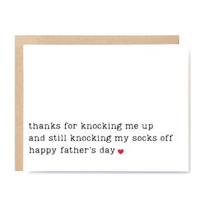 May include: A Father's Day card with a white background and a brown border. The card features the text "thanks for knocking me up and still knocking my socks off happy father's day" with a red heart.