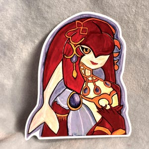 May include: A die-cut sticker featuring a stylized illustration of a humanoid character with long, flowing red hair, a pale complexion, and large amber eyes. The character wears a gold-toned collar with dark blue gems and a red and white garment.
