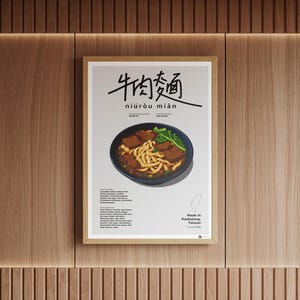 Op de afbeelding: Een ingelijste poster met een kom rundvleesnoedelsoep, met de Chinese karakters voor 'rundvleesnoedel' bovenaan. De poster bevat de tekst 'niúròu miàn' en details over het gerecht, met een kaart van Taiwan en de tekst 'Made in Kaohsiung, Taiwan'.