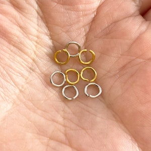May include: A collection of gold and silver jump rings, perfect for jewelry making.