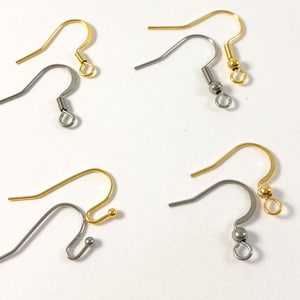 May include: Four pairs of earring hooks, two gold and two silver, with a small ball at the end of each hook.