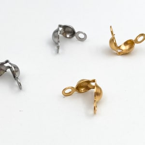 May include: Four metal clasps for jewellery making. Two are silver and two are gold.