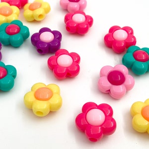 May include: Assortment of colorful plastic flower-shaped beads. The beads are in various colors, including pink, yellow, green, purple, and orange. Each bead has a small hole in the center for stringing.