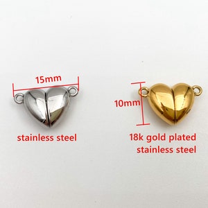 May include: Two heart-shaped magnetic clasps for jewelry making. The clasp on the left is made of stainless steel and measures 1.5 inches in diameter. The clasp on the right is 18k gold plated stainless steel and measures 1 inch in diameter.