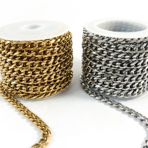 May include: Two spools of chain, one gold and one silver, are shown on a white background. The chain is a curb style chain.