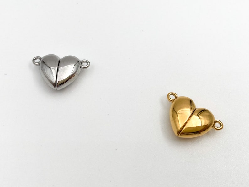 May include: Two heart-shaped magnetic clasps, one silver and one gold, for jewelry making.