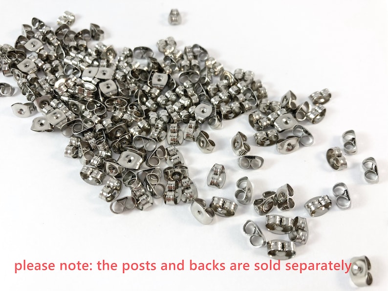 May include: A large pile of silver earring backs. The backs are made of metal and have a small loop on the top.  Please note: the posts and backs are sold separately.