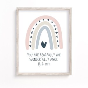 May include: A printable art print with a rainbow design in pink, beige, and blue with a black heart in the center. The text "You are fearfully and wonderfully made Psalm 139:14" is below the rainbow.