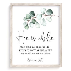 Könnte beinhalten: Ein weißer gerahmter Druck mit einer Aquarell-Illustration von Eukalyptusblättern. Der Druck zeigt den Text "He is able" und einen Bibelvers aus Epheser 3,20: "Unser Gott kann aber durch die Kraft, die in uns wirkt, weit mehr tun, als wir erbitten oder denken können."