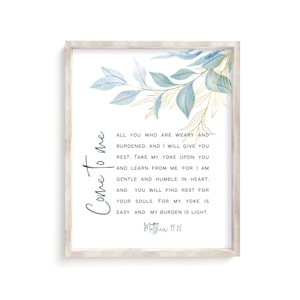 May include: A watercolor print with a blue and gold leafy design. The print features a quote from the Bible, Matthew 11:28, "Come to me, all you who are weary and burdened, and I will give you rest. Take my yoke upon you and learn from me, for I am gentle and humble in heart. And you will find rest for your souls. For my yoke is easy and my burden is light."