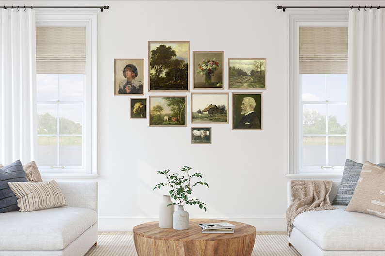 May include: A gallery wall with nine framed landscape paintings in various sizes and styles. The paintings feature scenes of nature, including trees, fields, and a farmhouse. The wall is painted white and the frames are a light wood color.