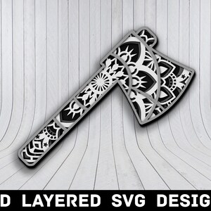 Könnte beinhalten: Ein schwarzes und weißes 3D-Schicht-SVG-Design einer Axt mit einem Mandala-Muster.