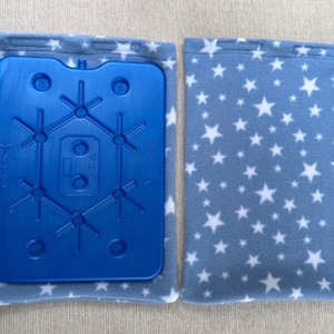 May include: A blue ice pack with a white star pattern fabric cover. The ice pack has a grid pattern with multiple small circles.