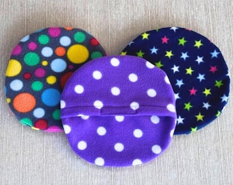 May include: Three round fleece fabric cushions with different patterns. One cushion has a dark blue background with colorful polka dots, another has a purple background with white polka dots, and the third has a dark blue background with yellow and pink stars.