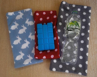 May include: Three fleece items: a blue bunny print, a red polka dot, and a gray polka dot. A blue ice pack rests on the red fabric. A clear water bottle with a green label sits on the gray fabric.