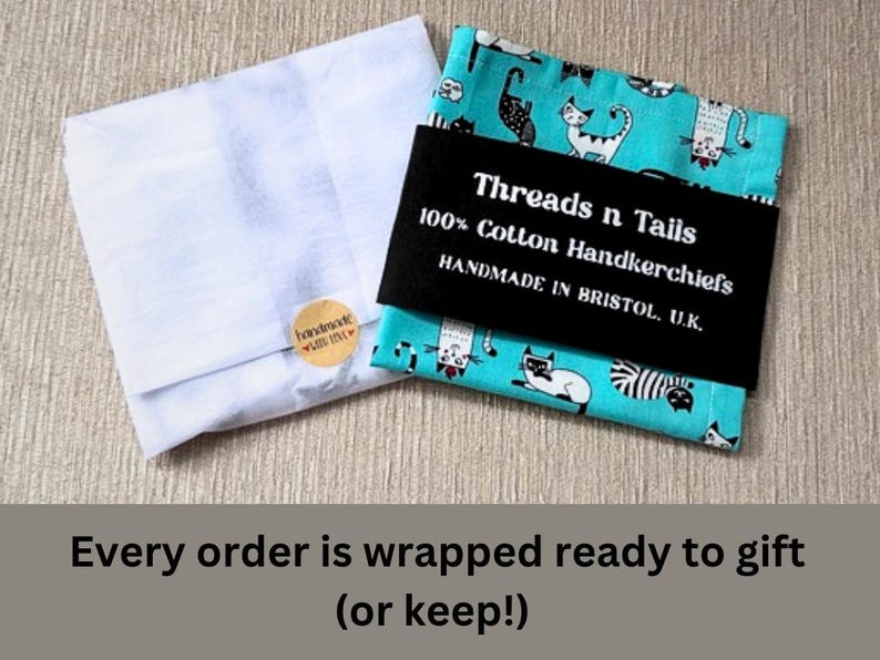 May include: Two handkerchiefs, one white and one teal with a cat pattern, are shown. The teal handkerchief is wrapped with a black band that reads "Threads n Tails 100% Cotton Handkerchiefs HANDMADE IN BRISTOL, U.K."