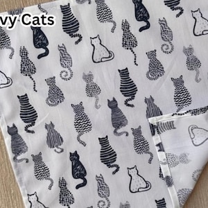 May include: White fabric with a navy cat pattern. The fabric features various cat illustrations in navy, with the words "Navy Cats" in the upper left corner. The cats are in different poses and styles.