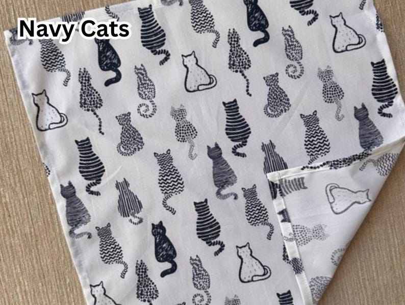 May include: White fabric with a navy cat pattern. The fabric features various cat illustrations in navy, with the words "Navy Cats" in the upper left corner. The cats are in different poses and styles.