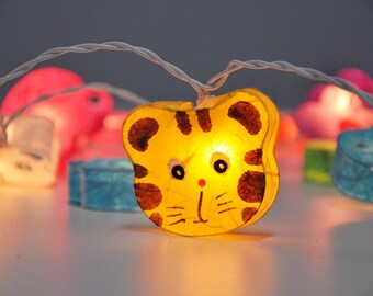 May include: A string of fairy lights with animal-shaped paper lanterns. The lanterns are lit and glow brightly. The lanterns are yellow, blue, pink, and white.