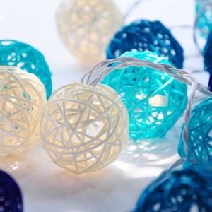 May include: A string of white and blue woven ball lights. The lights are strung together with a white wire. The balls are about 2 inches in diameter.