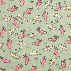 May include: A green fabric with a repeating pattern of pink rain boots and yellow and white striped umbrellas.
