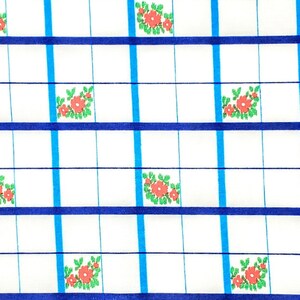 K&ouml;nnte beinhalten: Wei&szlig;er Stoff mit einem Gittermuster. Das Gitter wird durch blaue und hellblaue Linien gebildet. Kleine Gruppen roter Blumen mit gr&uuml;nen Bl&auml;ttern sind in einigen der Gitterquadrate platziert. Der Stoff hat ein sauberes, frisches Aussehen.