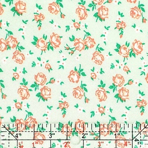 May include: A green fabric with a repeating pattern of small pink roses. The fabric is measured with a ruler in inches.