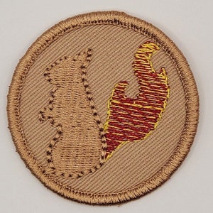 May include: A brown embroidered patch with a red and yellow outline of the state of New Jersey.