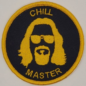 May include: A round, yellow embroidered patch with a black background. The patch features a cartoon image of a man with long hair and a beard wearing sunglasses. The text "CHILL MASTER" is embroidered in yellow around the image.