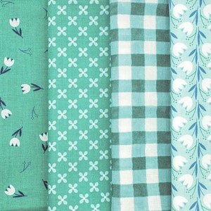 Pode incluir: Quatro amostras de tecido em padr&otilde;es diferentes: um tecido verde com flores brancas, um tecido verde com formas de trevo de quatro folhas brancas, um tecido xadrez verde e branco e um tecido verde com flores brancas e caules azuis.
