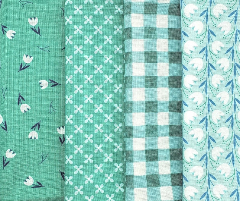 Pode incluir: Quatro amostras de tecido em padr&otilde;es diferentes: um tecido verde com flores brancas, um tecido verde com formas de trevo de quatro folhas brancas, um tecido xadrez verde e branco e um tecido verde com flores brancas e caules azuis.