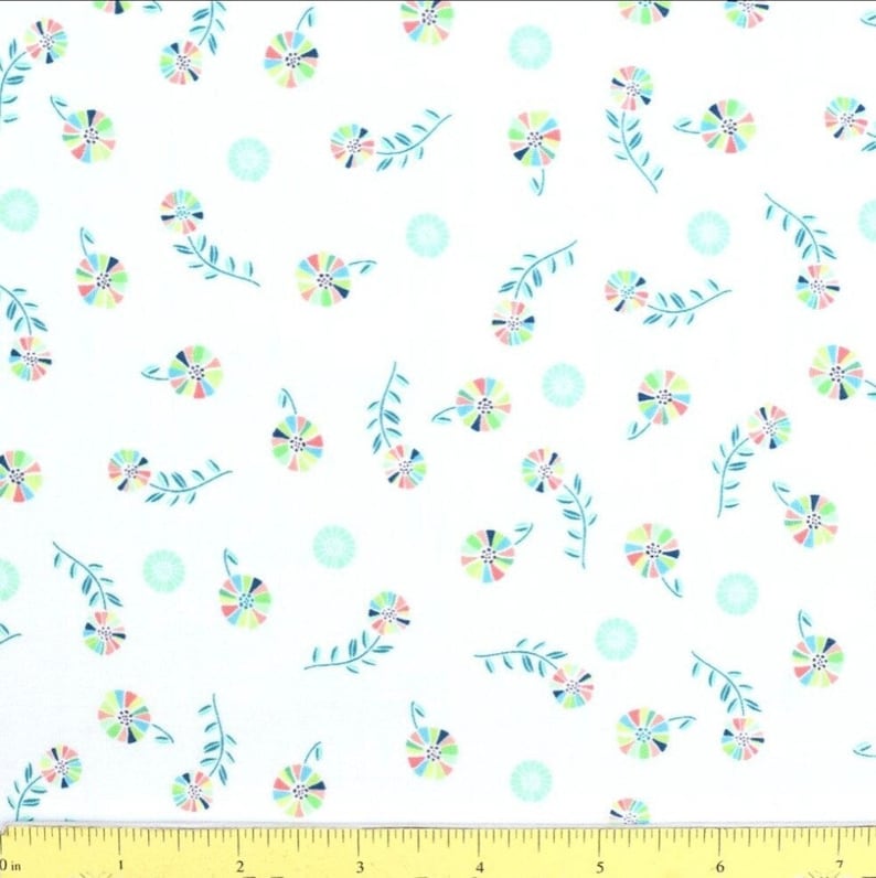 May include: White fabric with a repeating pattern of colorful flowers and teal leaves. The flowers have a rainbow of colors, and the leaves are a dark teal. There are also small, light teal circles scattered throughout the design.