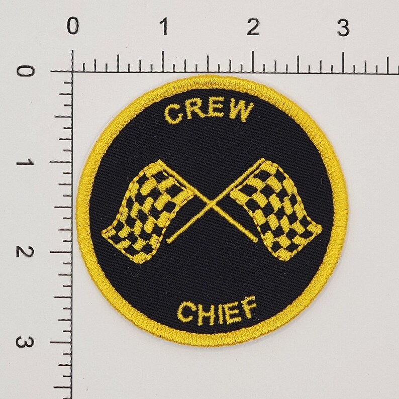 Pu&ograve; includere: Una toppa ricamata gialla e nera con le parole "CREW CHIEF" e due bandiere a scacchi incrociate.