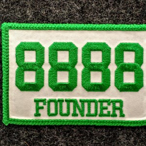 May include: Embroidered patch with a white background and green border. The patch features the number "8888" in green, above the word "FOUNDER" in green, all on a rectangular patch.