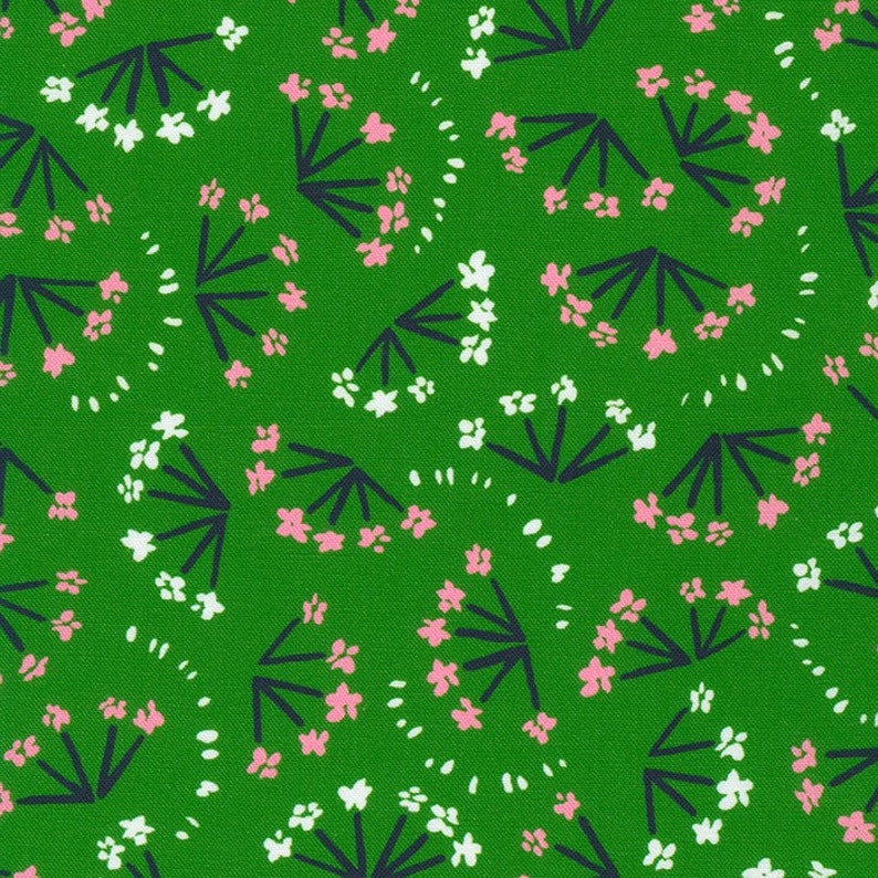 May include: A green fabric with a repeating pattern of white and pink flowers with dark blue stems. The flowers are arranged in clusters and are surrounded by small white dots.