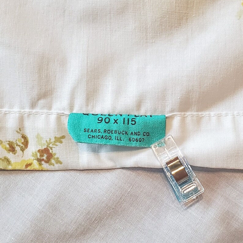 May include: A turquoise blue label with white text that reads "90 x 115 SEARS, ROEBUCK AND CO. CHICAGO, ILL. 60607".
