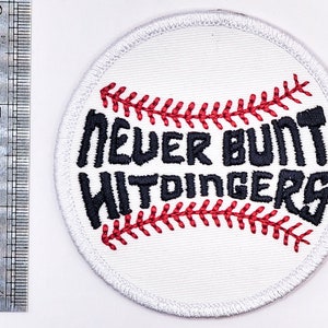 May include: White embroidered baseball patch with red stitching. The patch features the text "Never Bunt Widdingers" in black.
