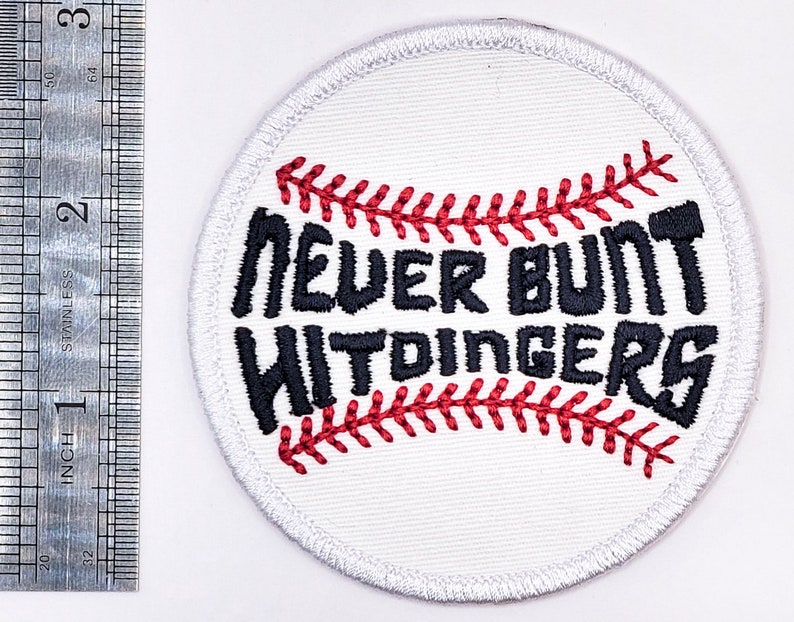 May include: White embroidered baseball patch with red stitching. The patch features the text "Never Bunt Widdingers" in black.