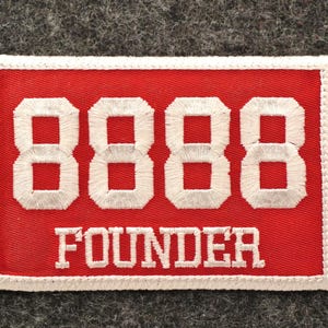 May include: Embroidered red patch with white stitched border. The patch features the number "8888" in white block letters above the word "FOUNDER" in white capital letters. The patch is rectangular.