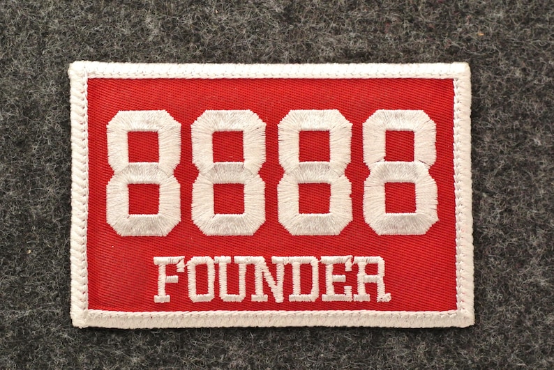 May include: Embroidered red patch with white stitched border. The patch features the number "8888" in white block letters above the word "FOUNDER" in white capital letters. The patch is rectangular.