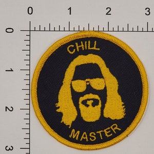 May include: A round, black and gold embroidered patch with the text "CHILL MASTER" and a silhouette of a man with a beard and sunglasses.