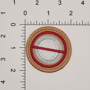 May include: A brown embroidered patch with a red circle and a white circle inside. The red circle has a red line across it.