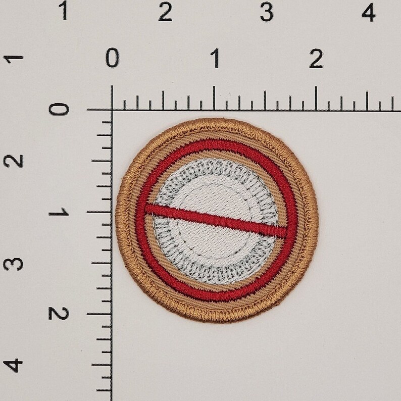 May include: A brown embroidered patch with a red circle and a white circle inside. The red circle has a red line across it.